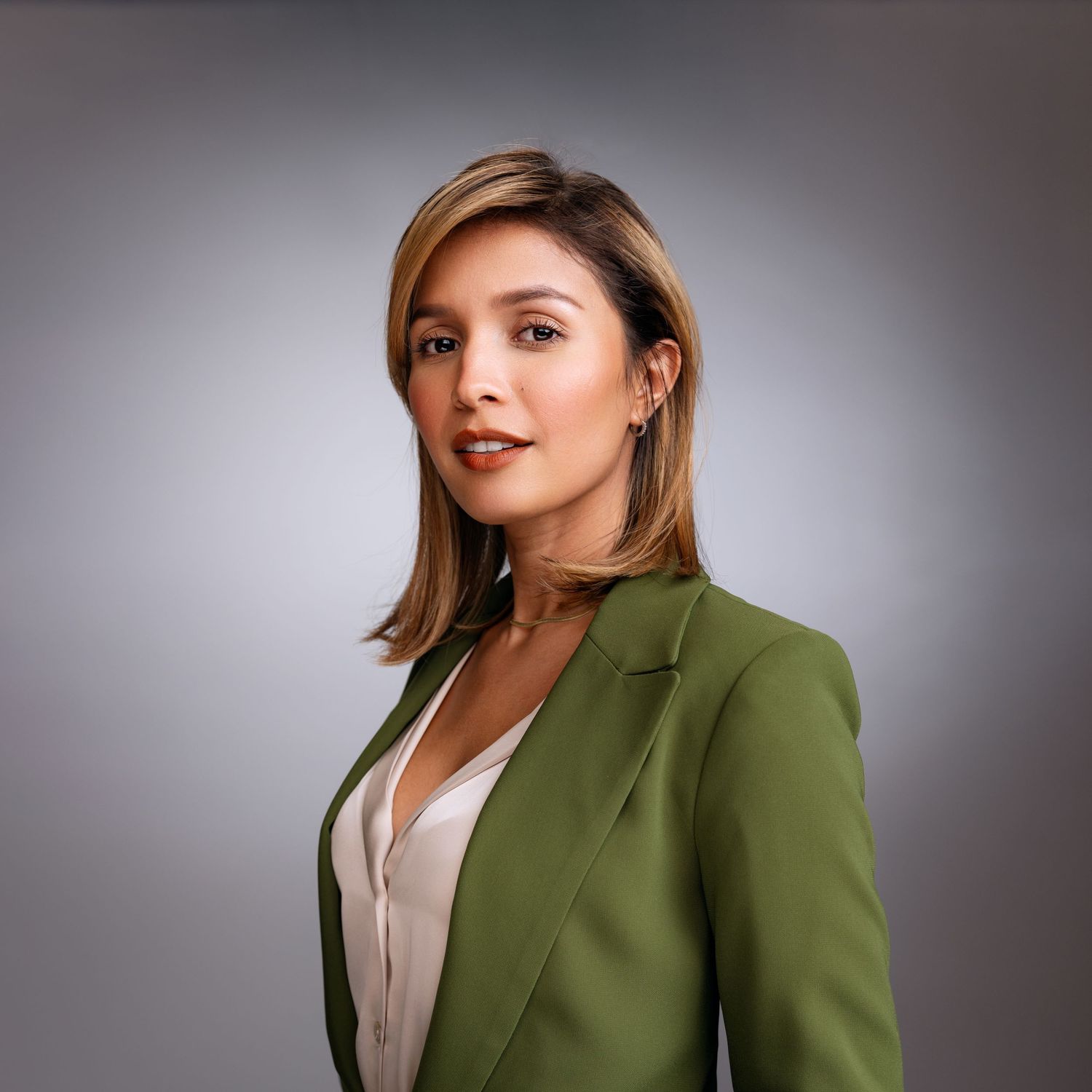 Realtor headshot in studio of female agent wearing green blazer in Fort Lauderdale.