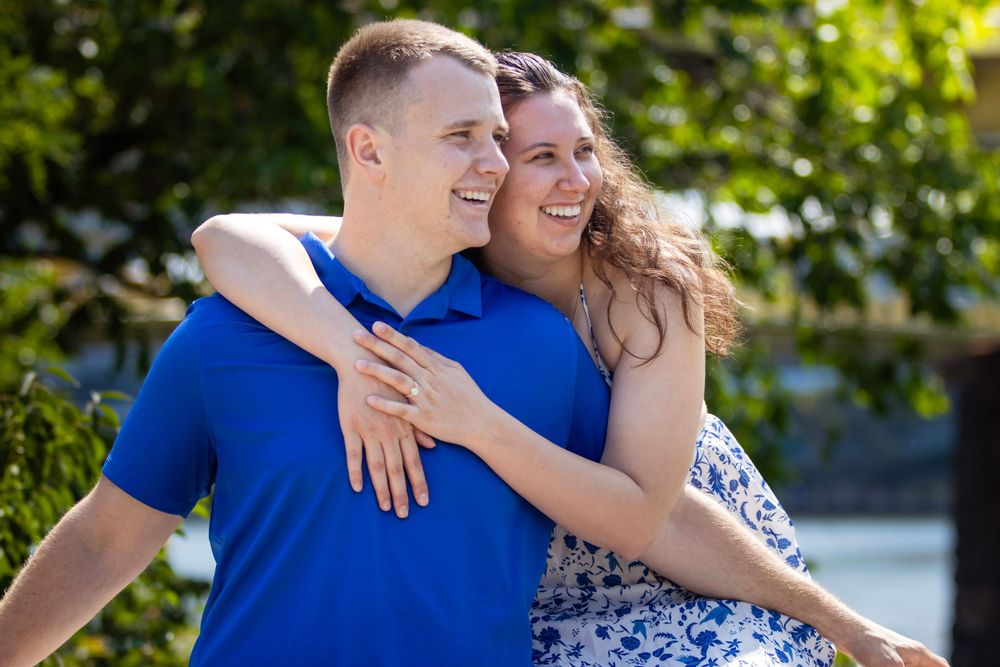 Couple in matching blue outfits embrace outdoors on a sunny day.