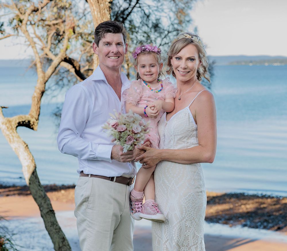 A scenic waterfront wedding portrait with a coastal backdrop. Redlands
