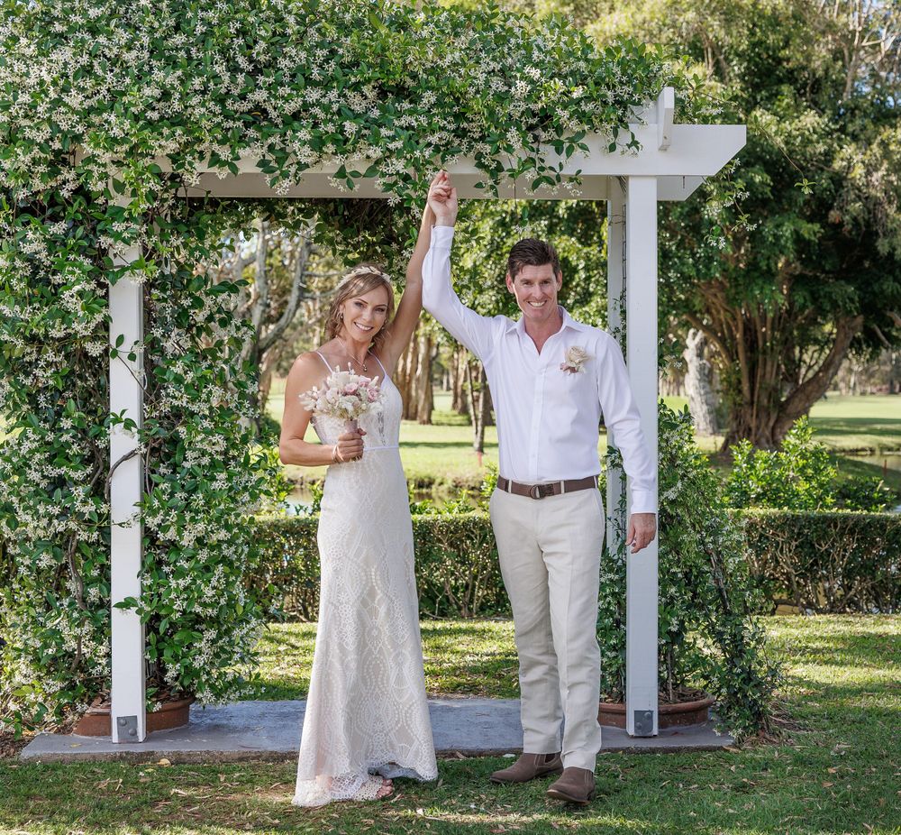Elegant garden wedding ceremony setup with white pillars and natural greenery. Redlands
