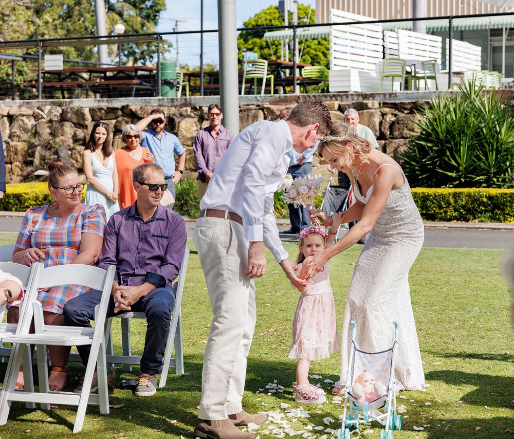 Wedding celebration with guests enjoying themselves on a sunny lawn with white chairs. Redlands