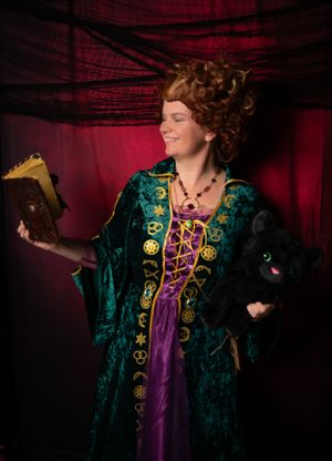 Costume photoshoot featuring emerald velvet coat with gold embroidery and purple accents.