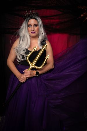 A dramatic fashion shot with flowing purple tulle and golden props.