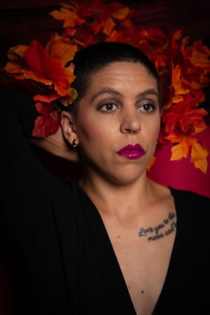 An autumn-themed portrait with orange leaves and dark background.