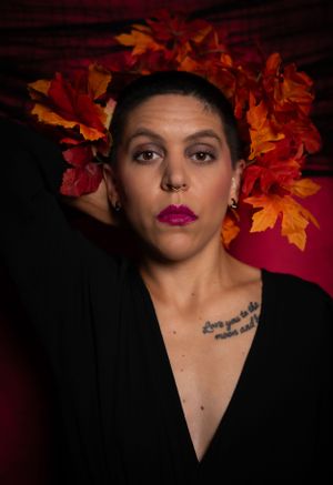 A dramatic portrait with orange fall leaves and dark attire.