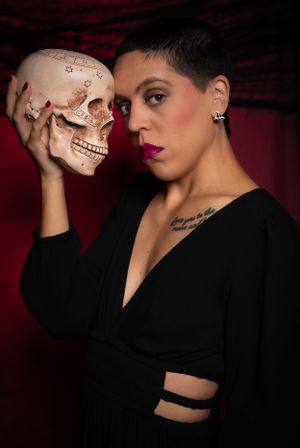 Dramatic portrait series with a skull prop against dark red background creating moody atmosphere.