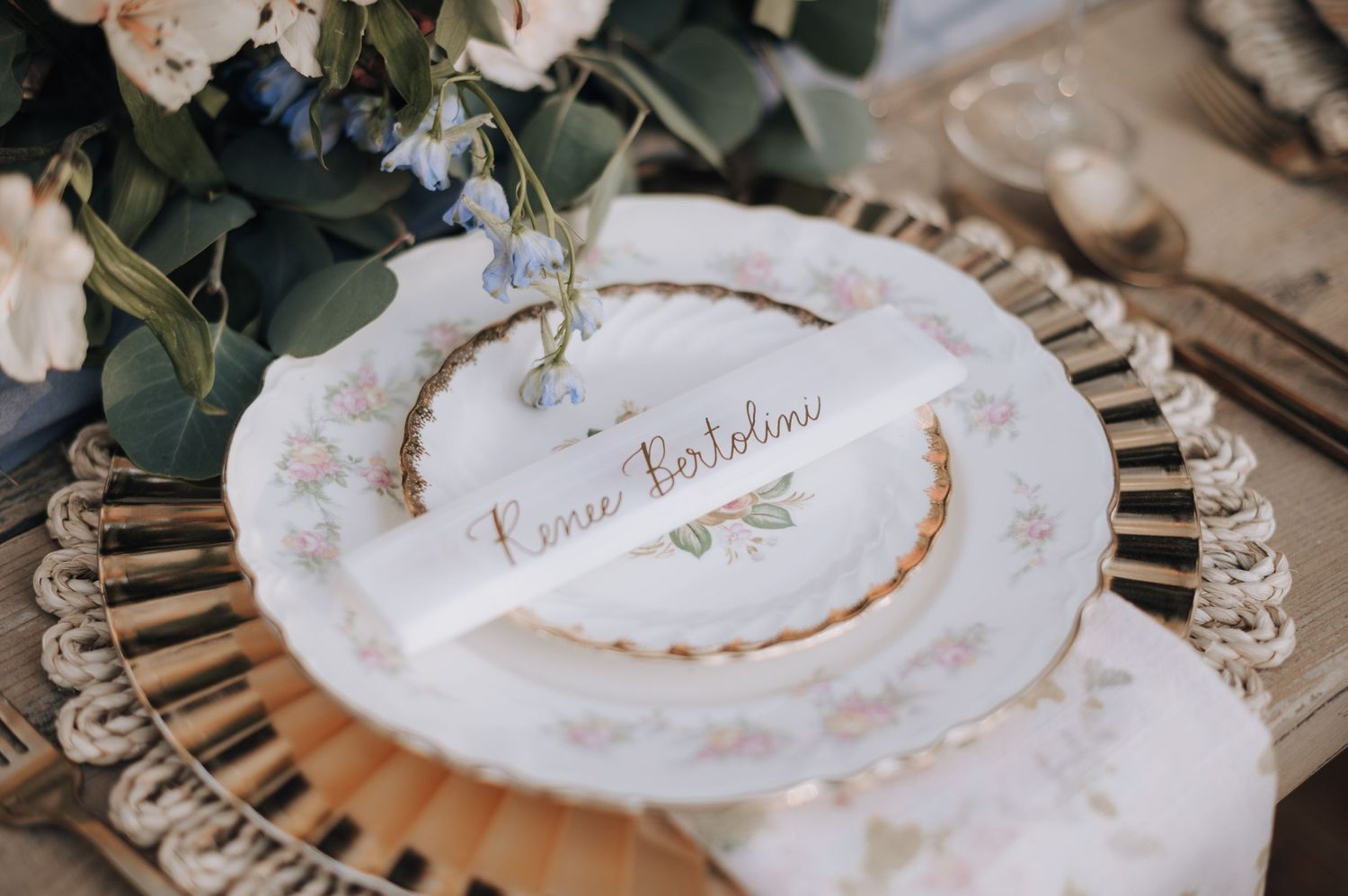 Decorative place setting with delicate floral pattern and gold accents.