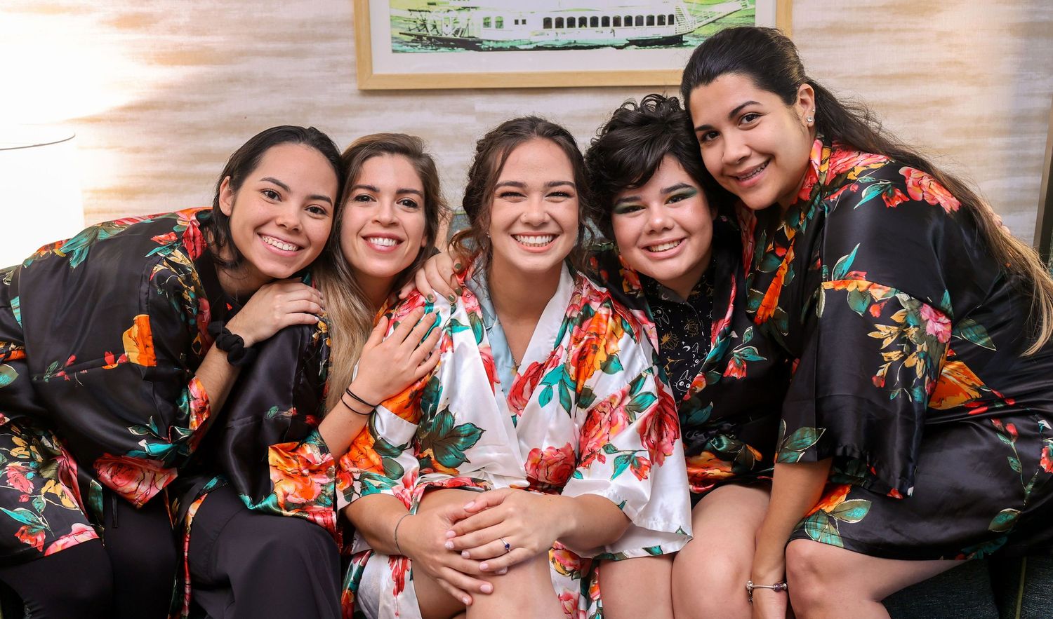 A group wearing matching floral robes pose together during a celebration event.