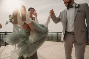 Joyful dancing moment captured during wedding celebration on outdoor deck.