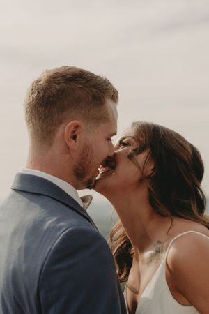 Intimate close-up of couple sharing romantic kiss with soft lighting.