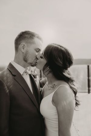 Black and white intimate portrait of couple sharing romantic kiss.