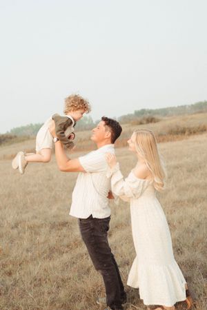 Joyful family moment captured in golden field during sunset.