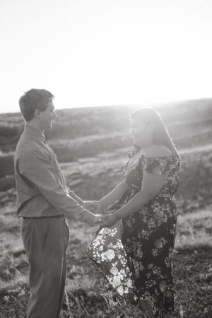 Romantic black and white couple portrait in a sunlit meadow.