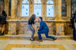 A special moment captured in an ornate marble hallway with arched windows.