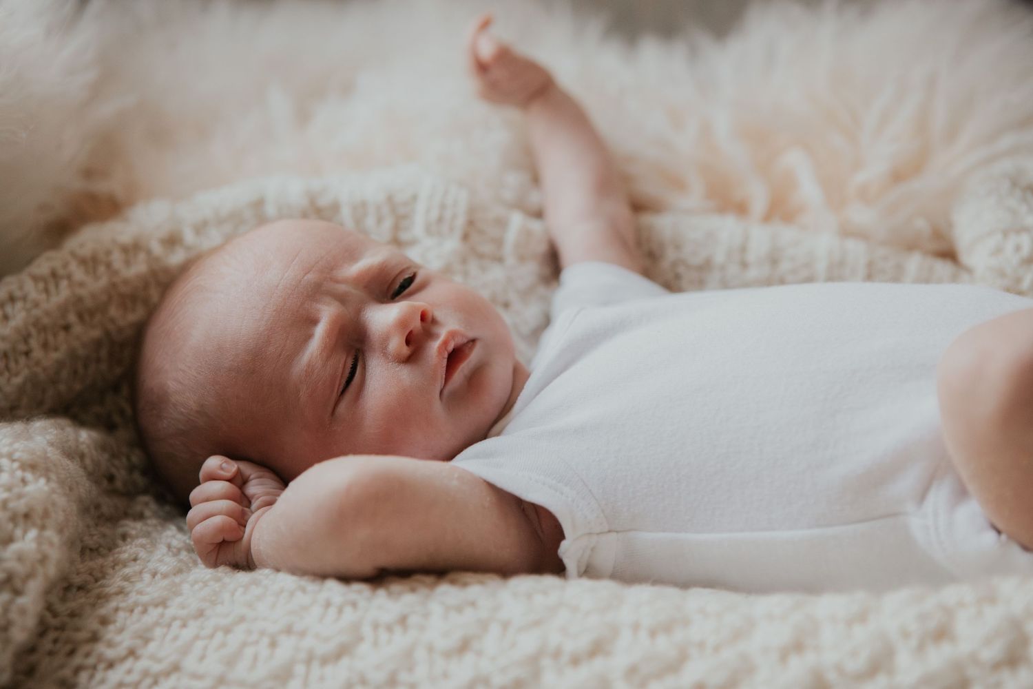 New born at home photo shoot with Cornwall new born photographer  baby stretching