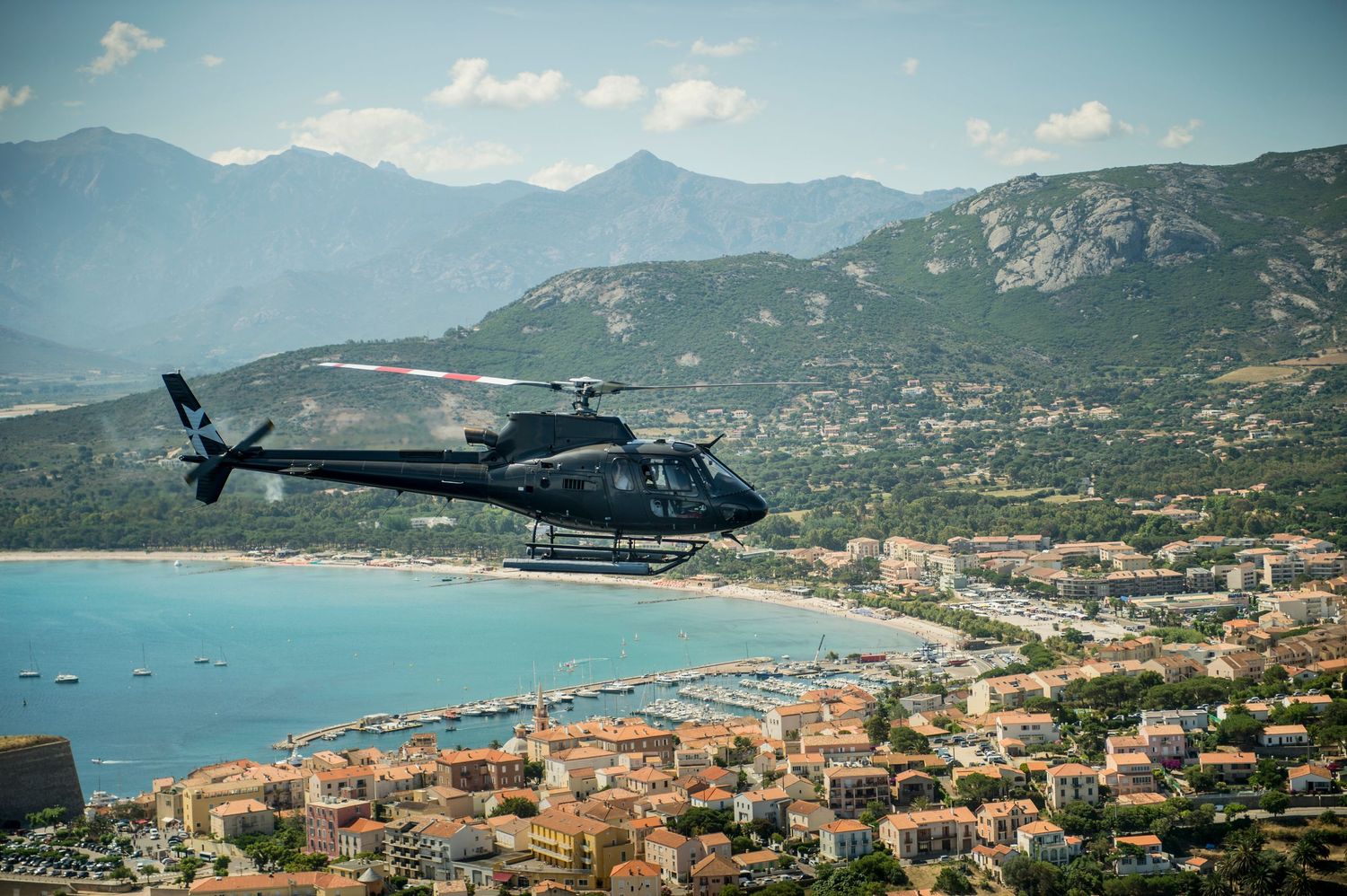 Helicopter flies over the port of Calvi in Corsica, Marketing Event Photography image