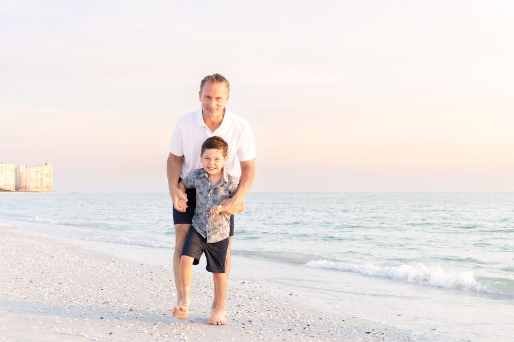 father and son playing at beach pretty sunset