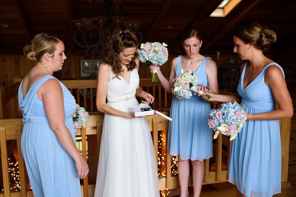 Bride opens gift on her wedding day at Crystal Brook Farm in Chagrin Falls, Ohio.