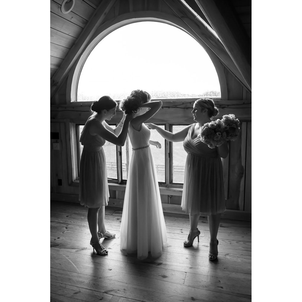 Bridesmaids helping bride get ready for wedding day at Crystal Brook Farm in Chagrin Falls, Ohio.
