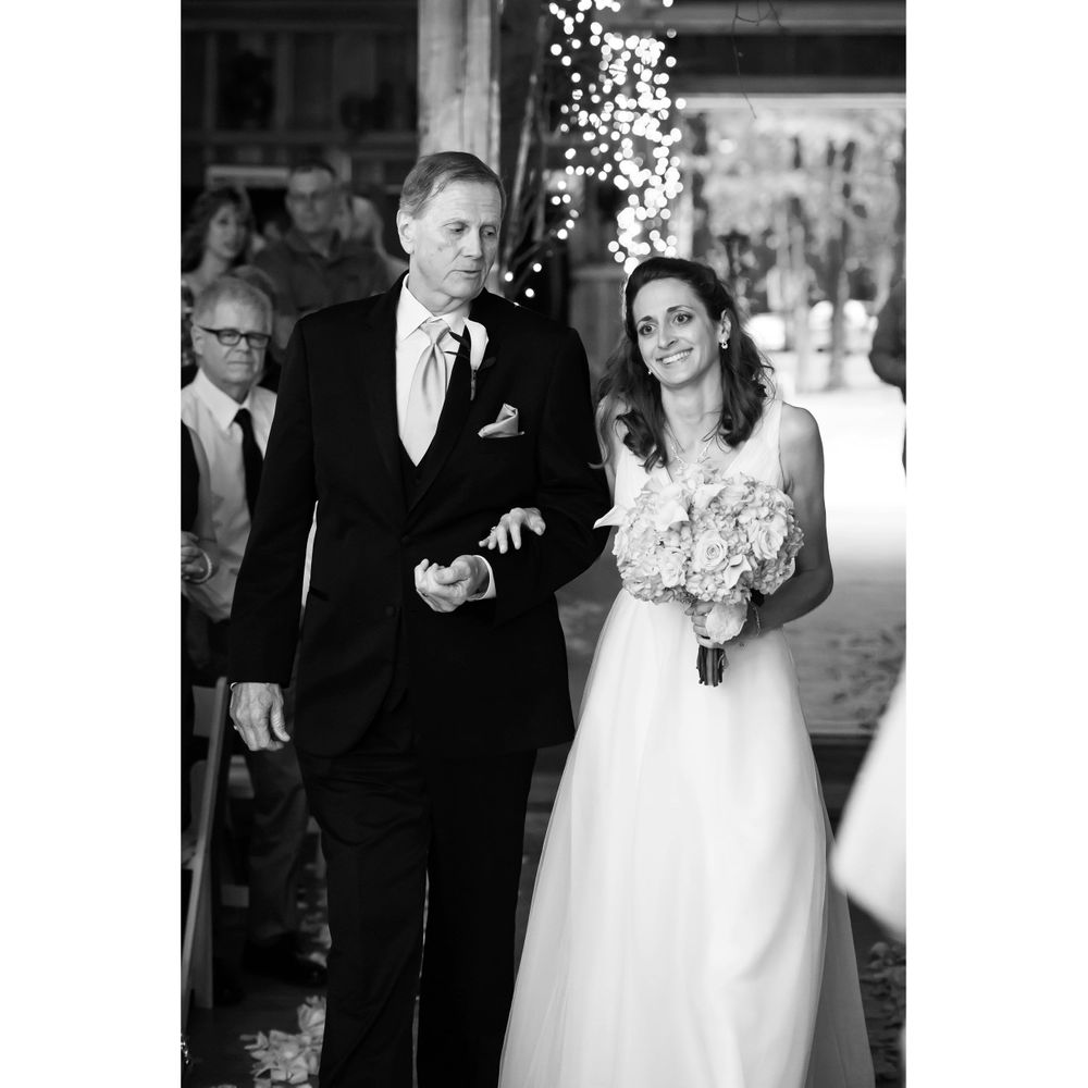Father walks bride down aisle during wedding ceremony at Crystal Brook Farm in Chagrin Falls, Ohio.