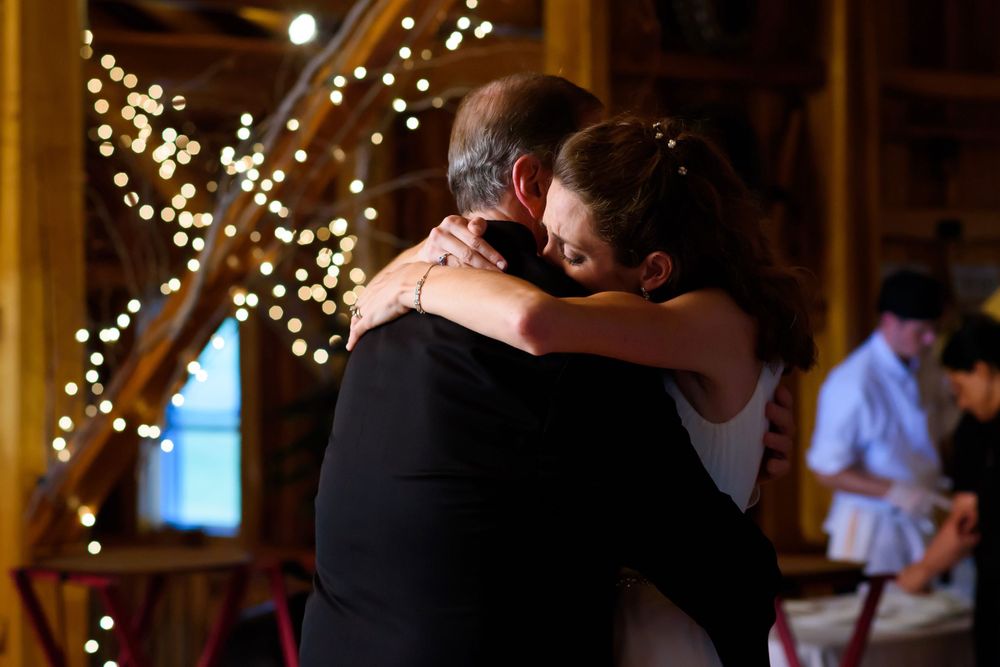 Bride hugs father during wedding reception at Crystal Brook Farm in Chagrin Falls, Ohio.