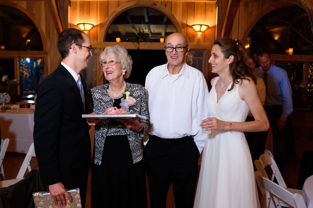 Bride and groom present gifts to grandparents during wedding reception at Crystal Brook Farm in Chagrin Falls, Ohio.