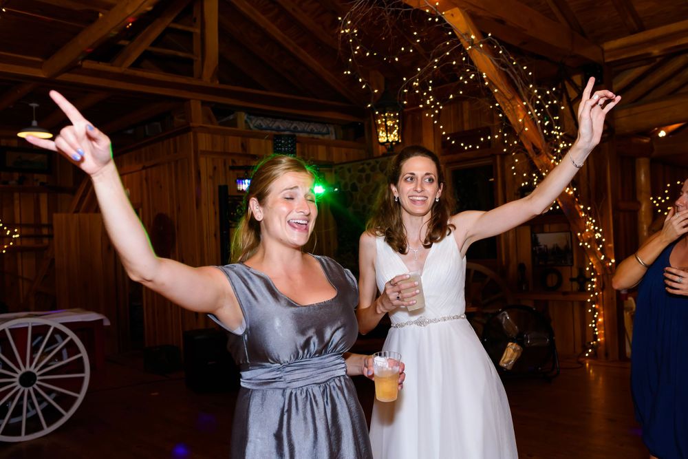 Bride and bridesmaid on dance floor during wedding reception at Crystal Brook Farm in Chagrin Falls, Ohio.