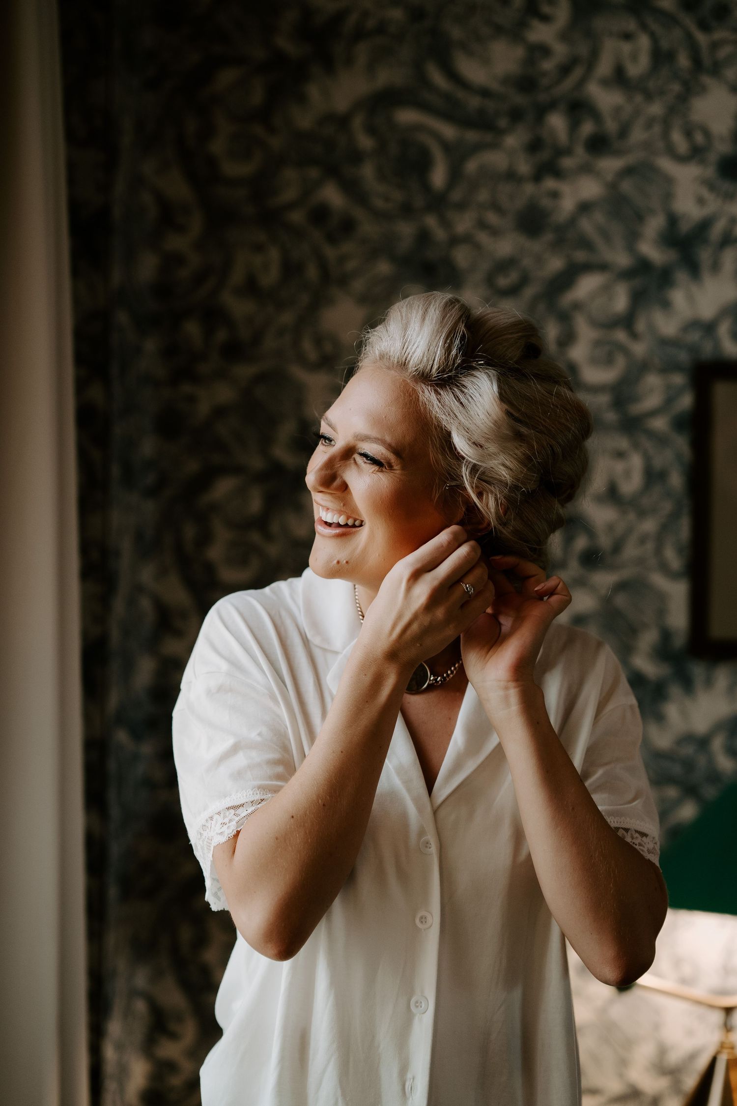 bride fastening earrings at the Randolph hotel in Oxford