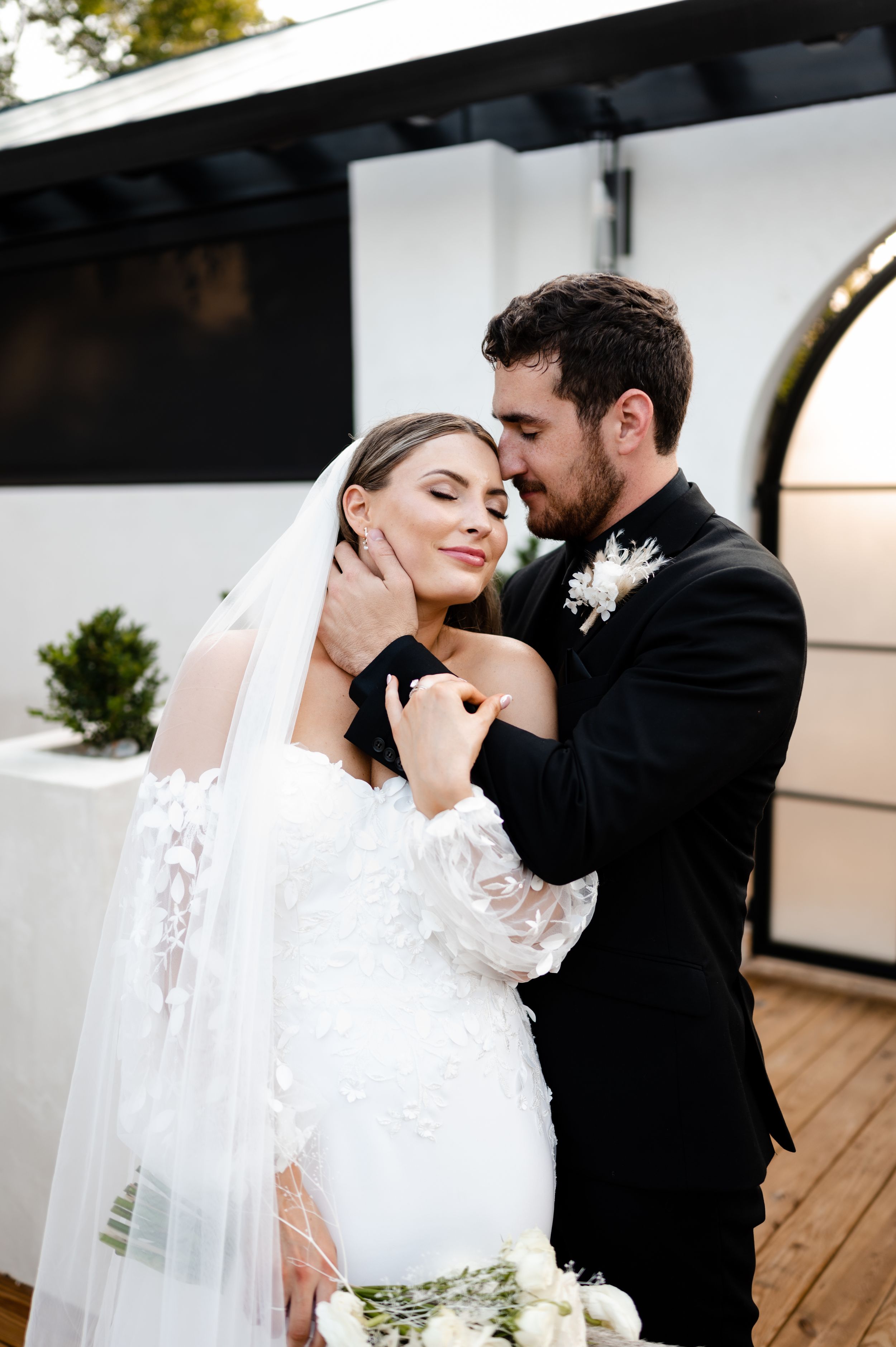 Intimate wedding portrait capturing tender moment between newlyweds.