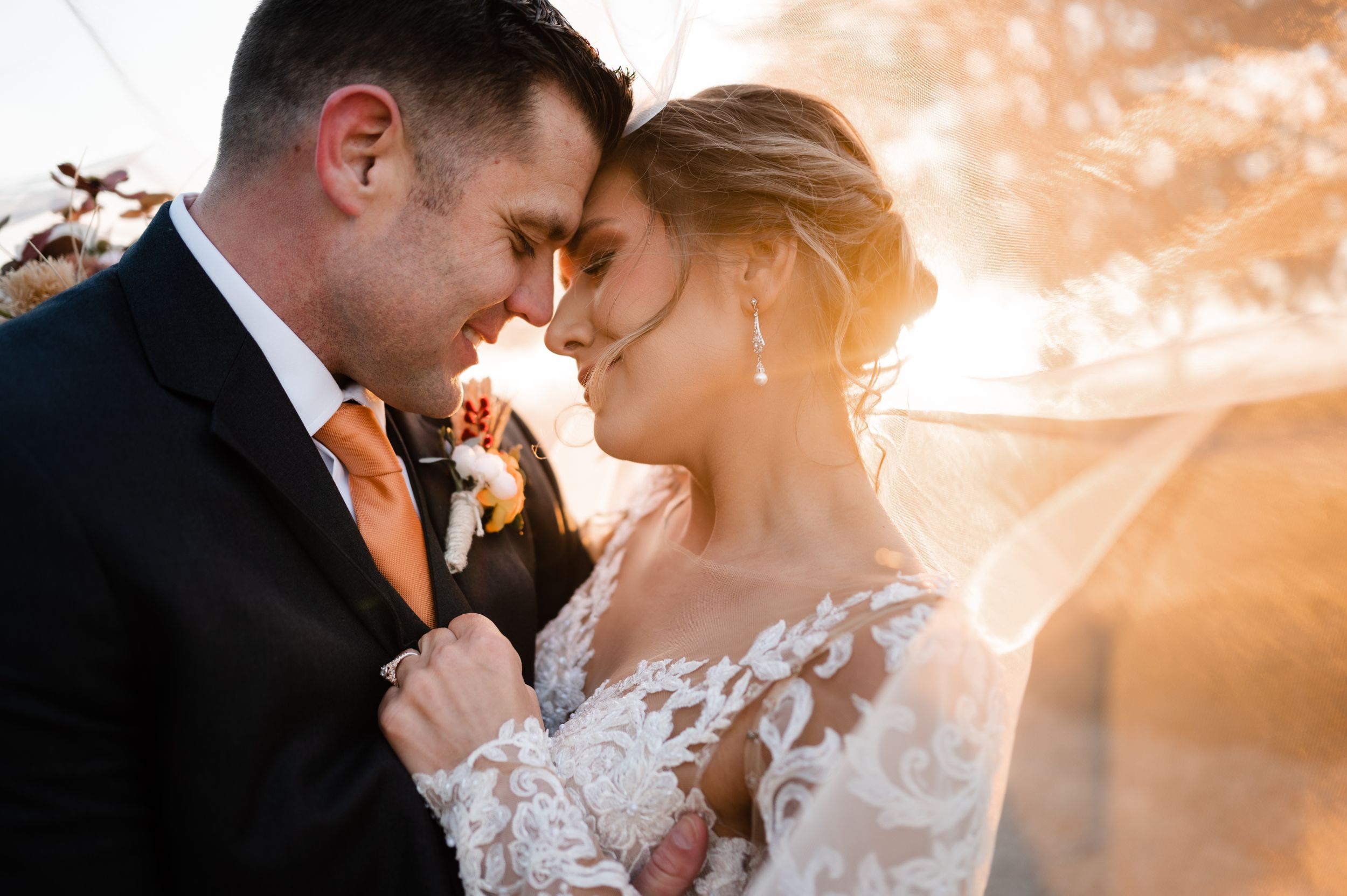 Romantic sunset moment between newlyweds with soft lighting.