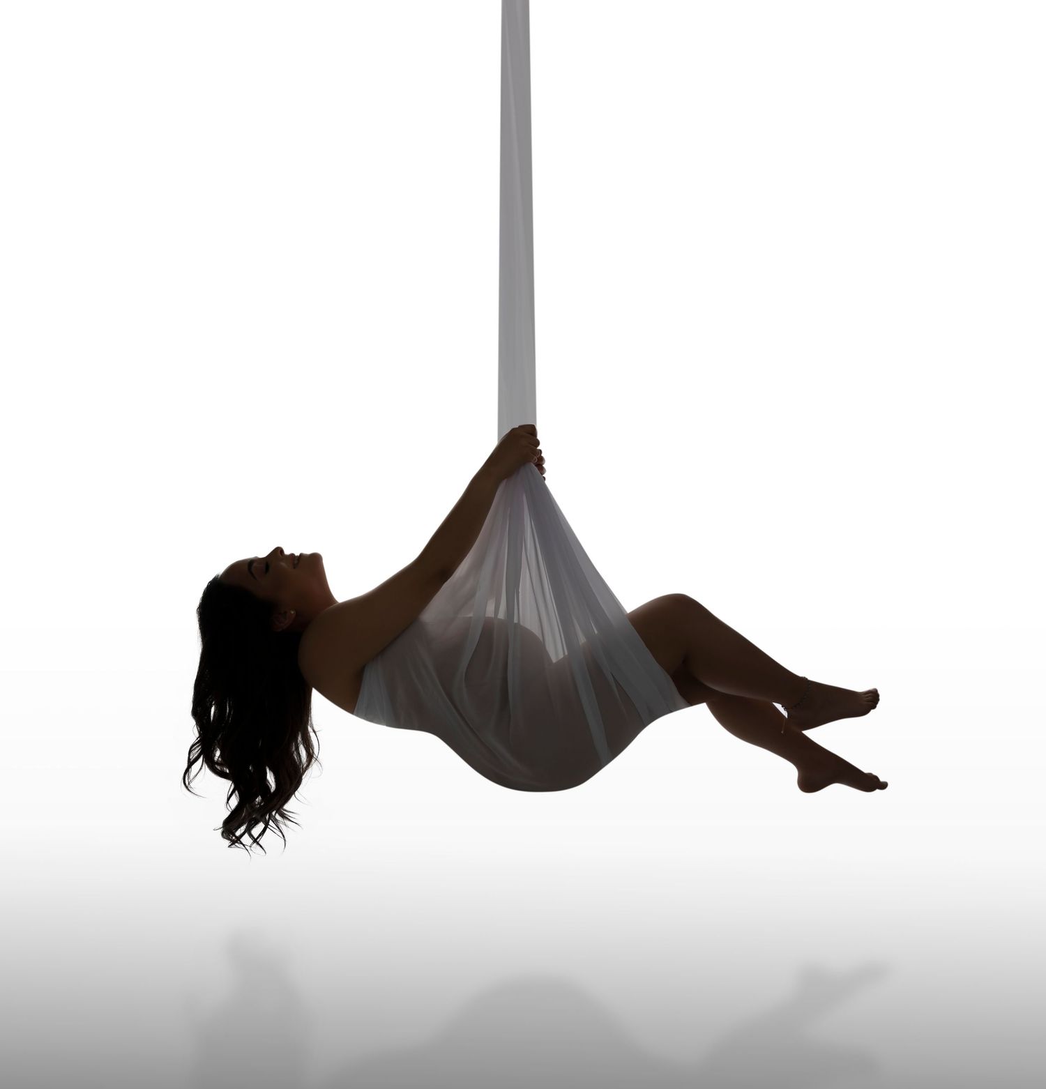 Creative maternity silhouette series against white background showing elegant suspended poses.
