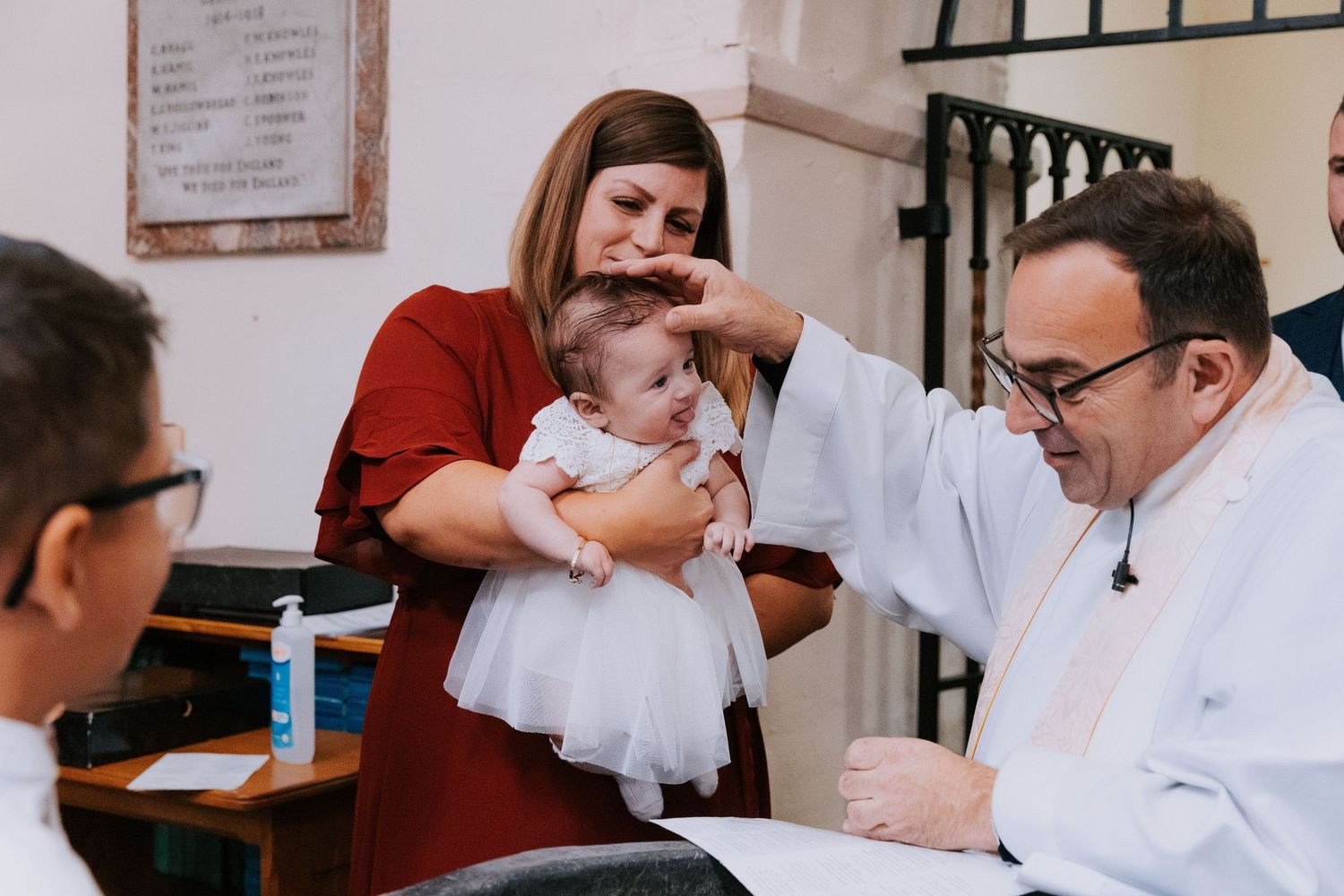 Church members gather around a baptismal font during a religious ceremony.