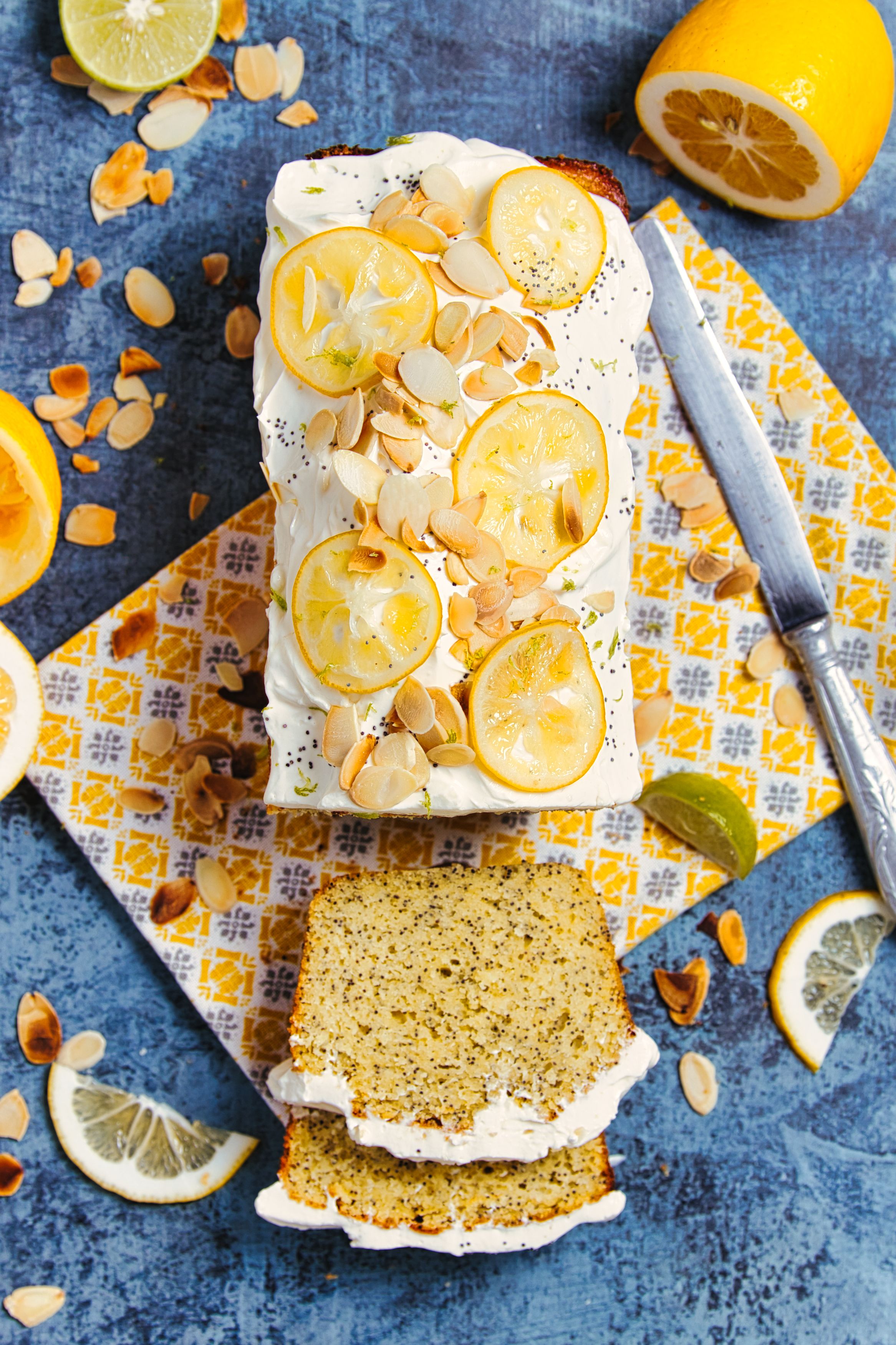 Lemon dessert with almonds and cream on blue textured surface.