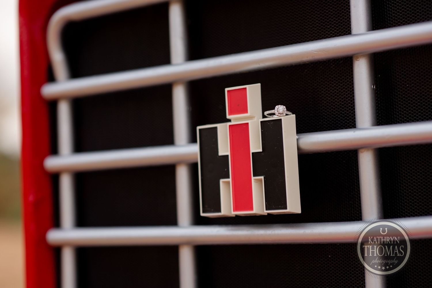 Close-up detail of a vintage International Harvester logo on red farm equipment.