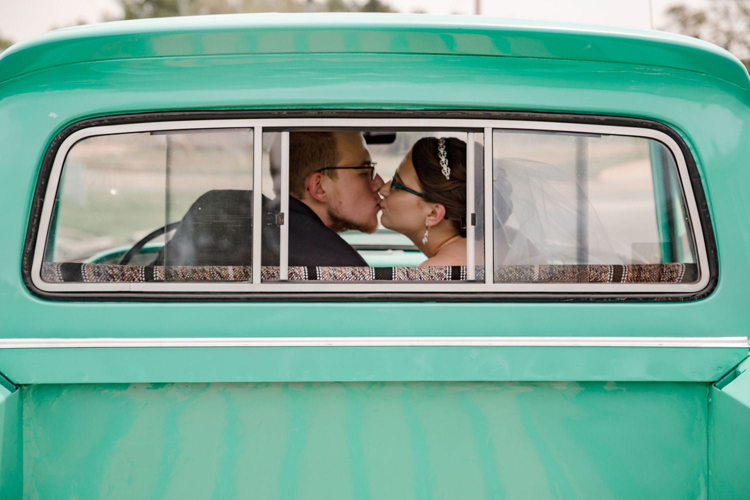 bride and groom leaning in for kiss sitting in vintage truck by Vine Photography in Salem Ohio
