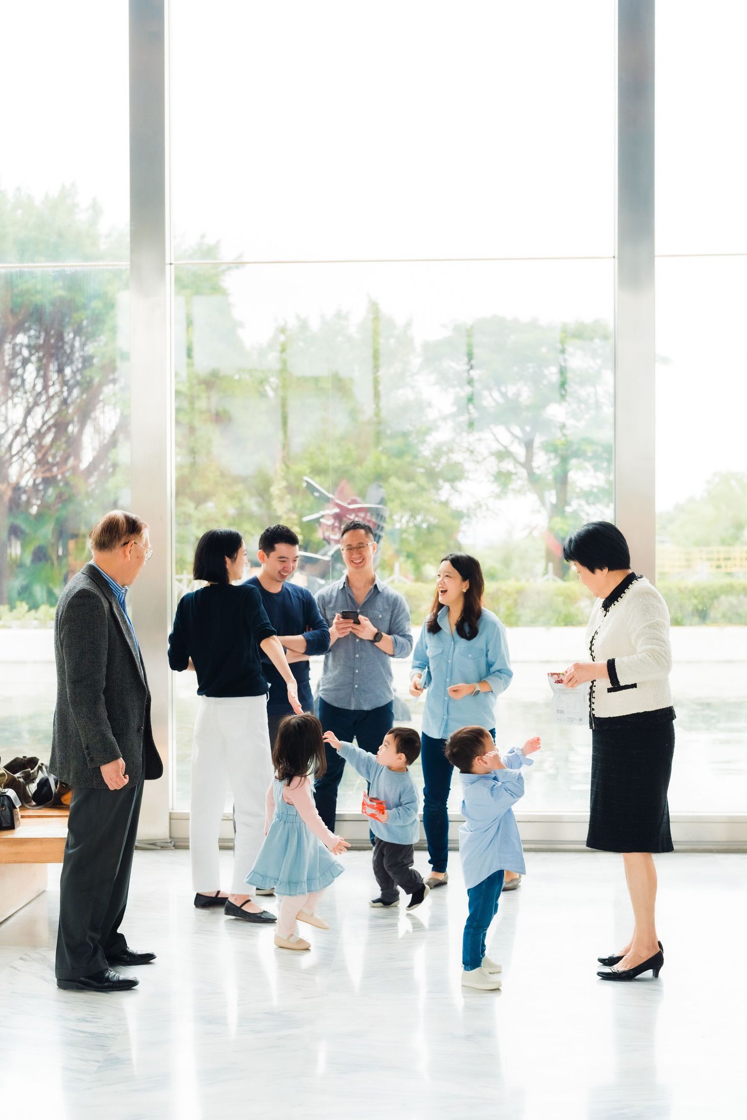 Group gathering in bright modern space with floor to ceiling windows.