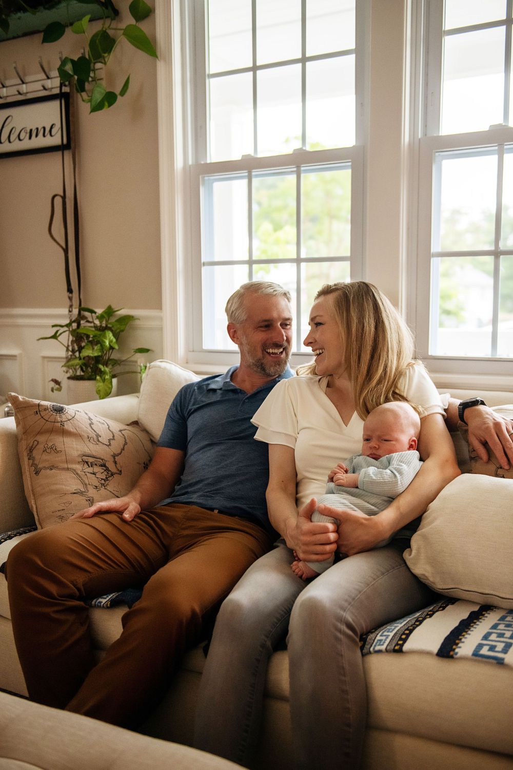 Candid family moments captured on comfortable sofa in sunlit living room.