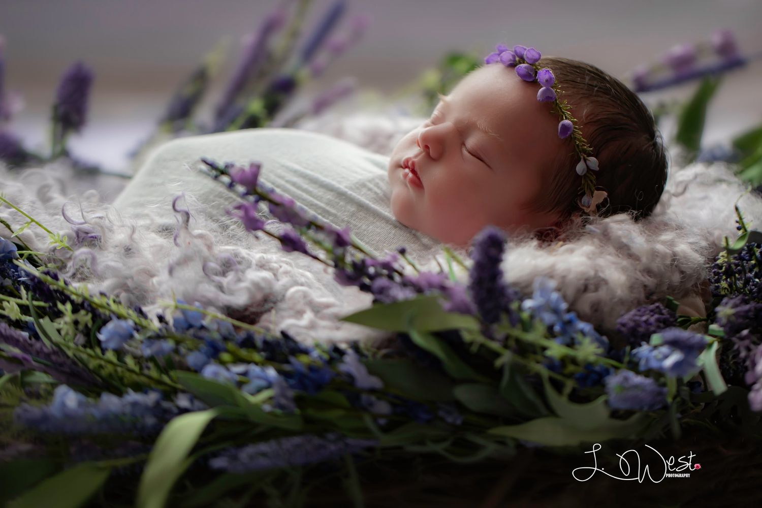 Serene newborn photography with lavender flowers and soft white bedding.