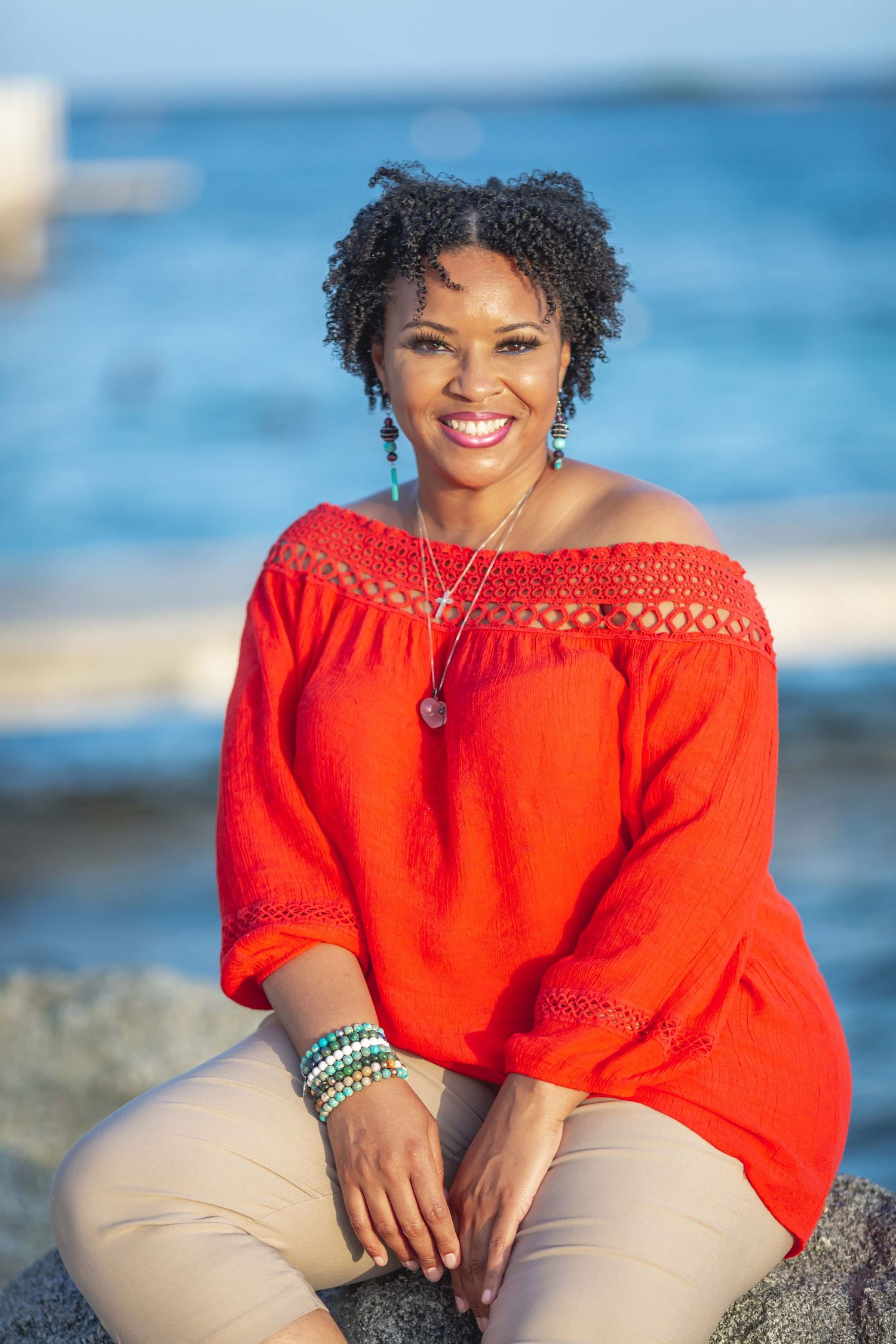 Young  lady sitting on rocks on beach