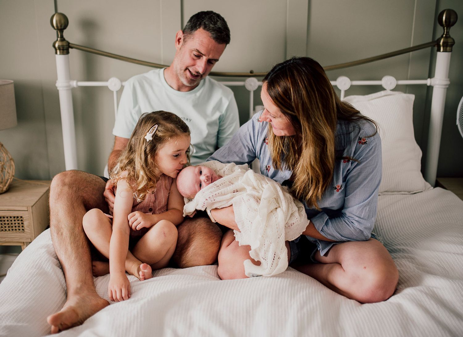 Intimate family moments captured on white bedding in natural light. Worcestershire Wedding photographer.