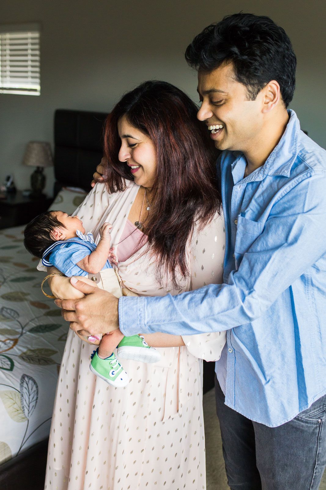 Bellevue newborn photographer captures parents smiling and tickling newborn baby