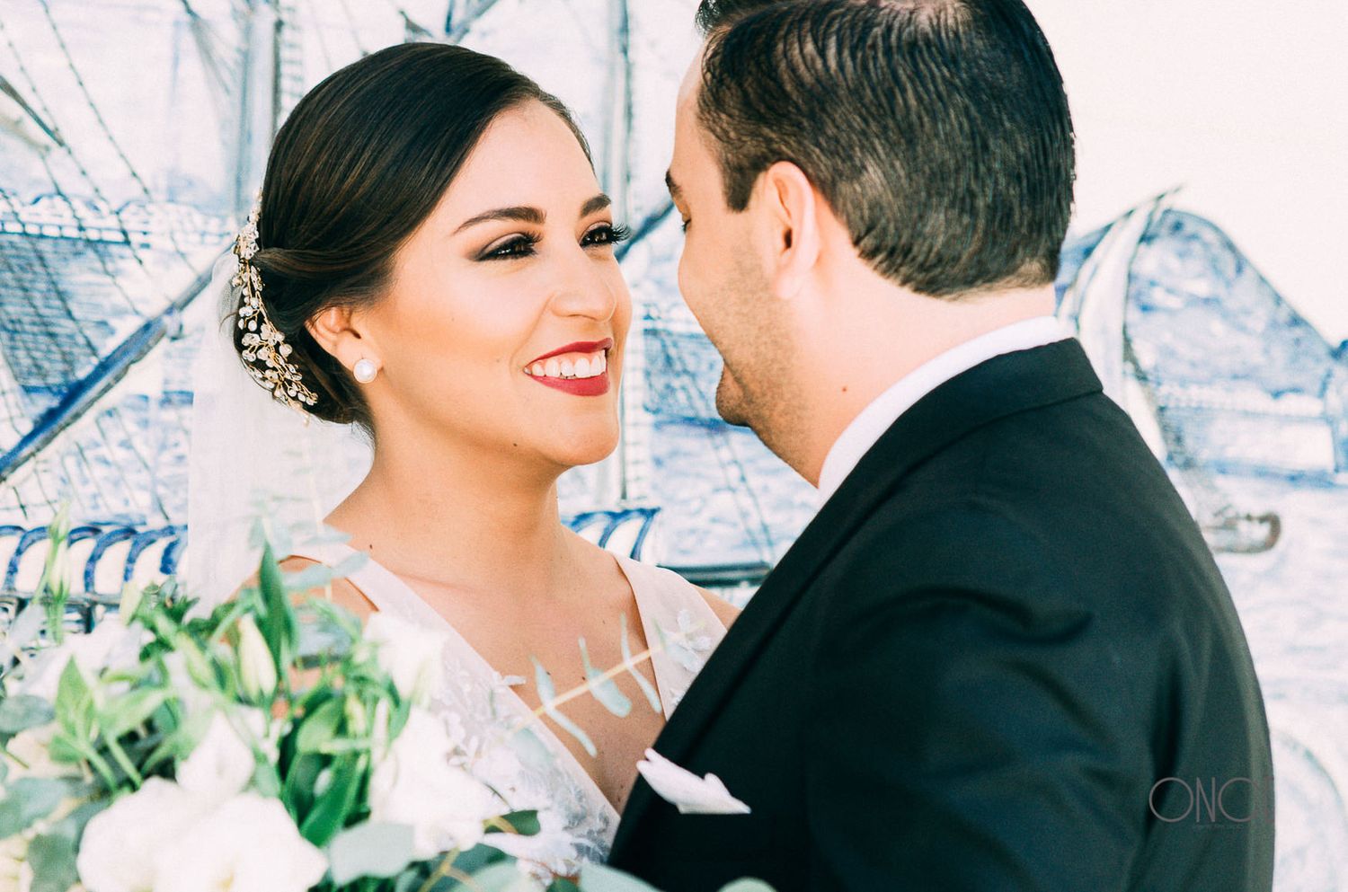 A romantic moment between newlyweds with the bride wearing an elegant white lace dress.
