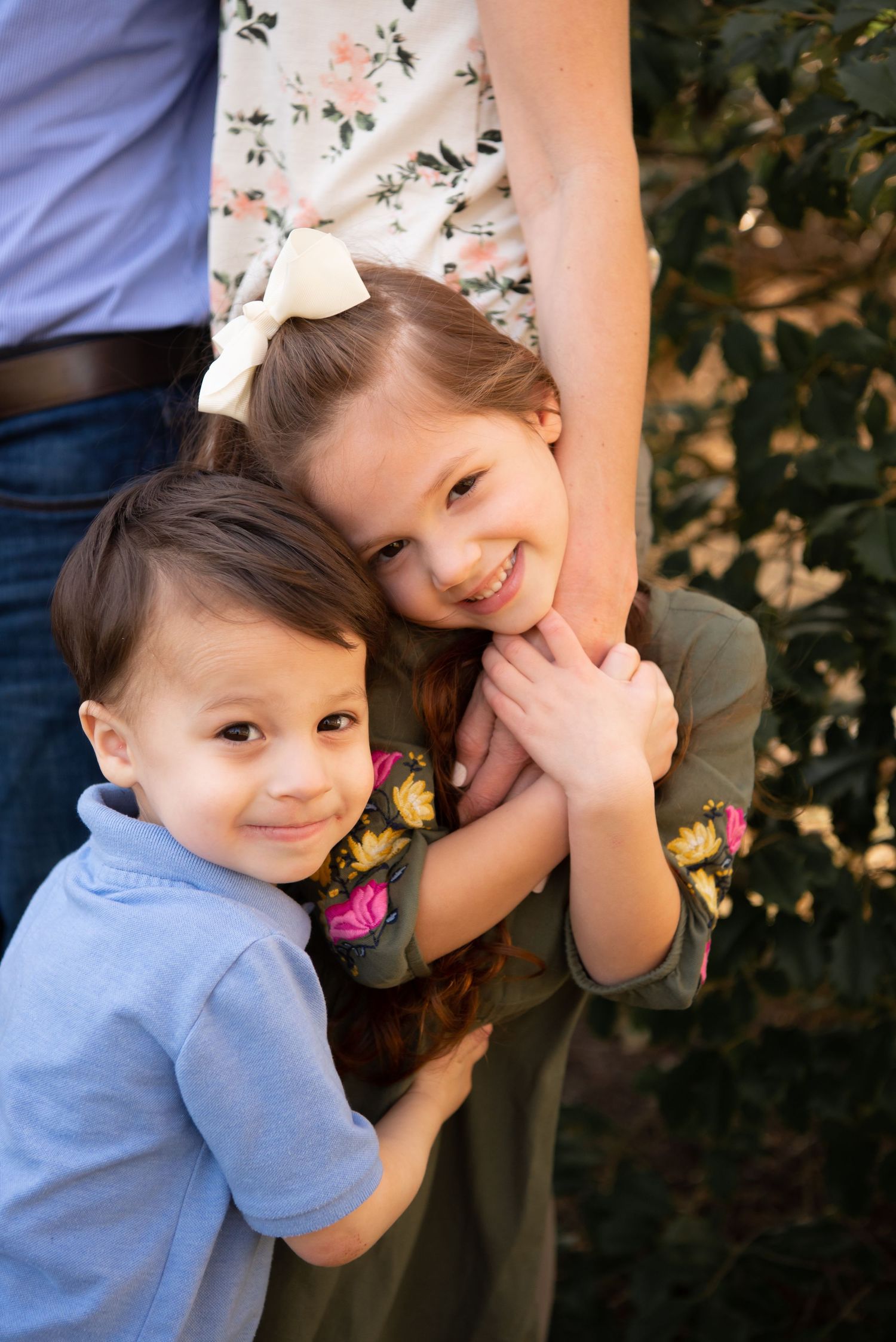 toddler brother and sister holding parents hands