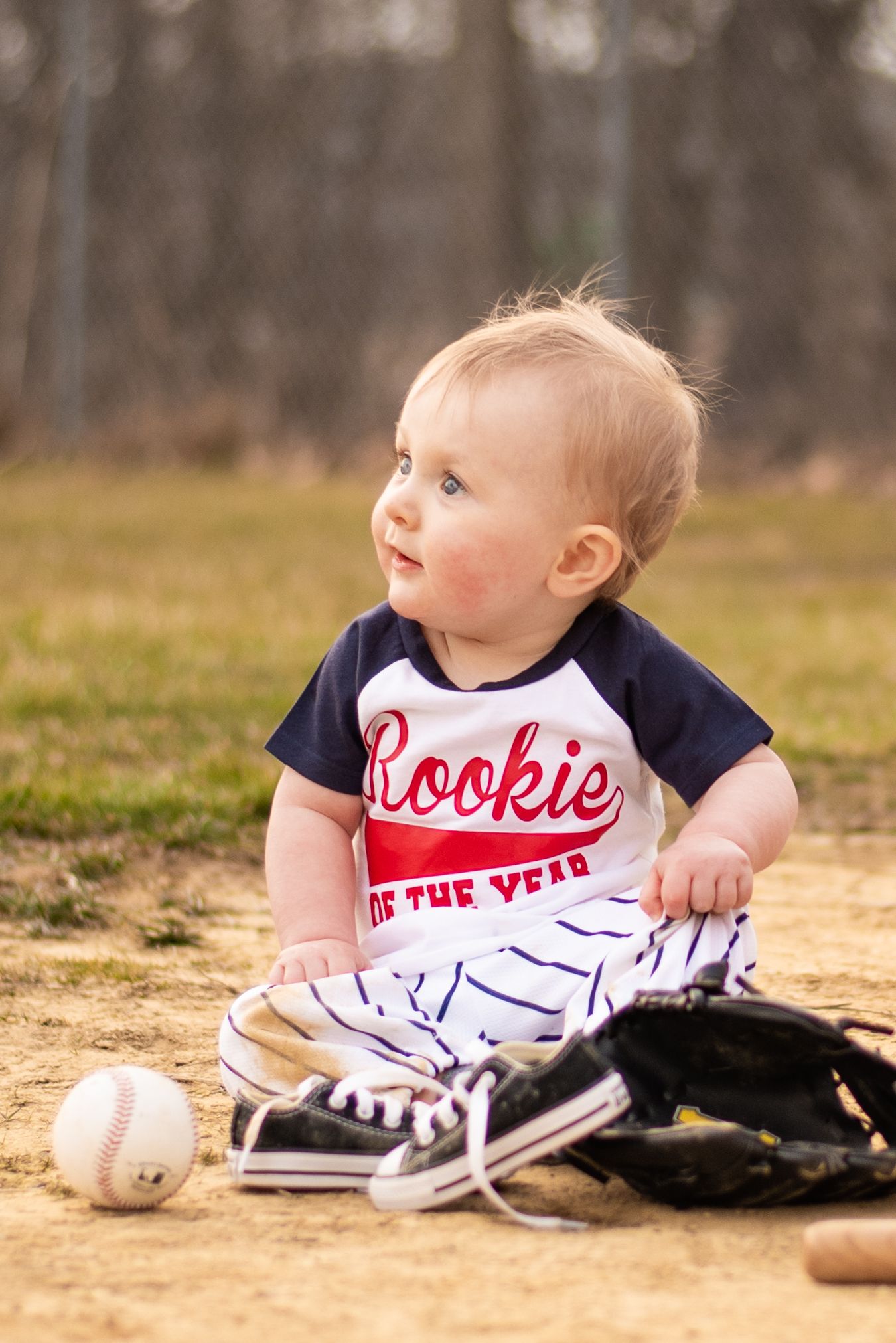 first birthday in baseball clothes with a bat sitting in a field in hampton pennsylvania