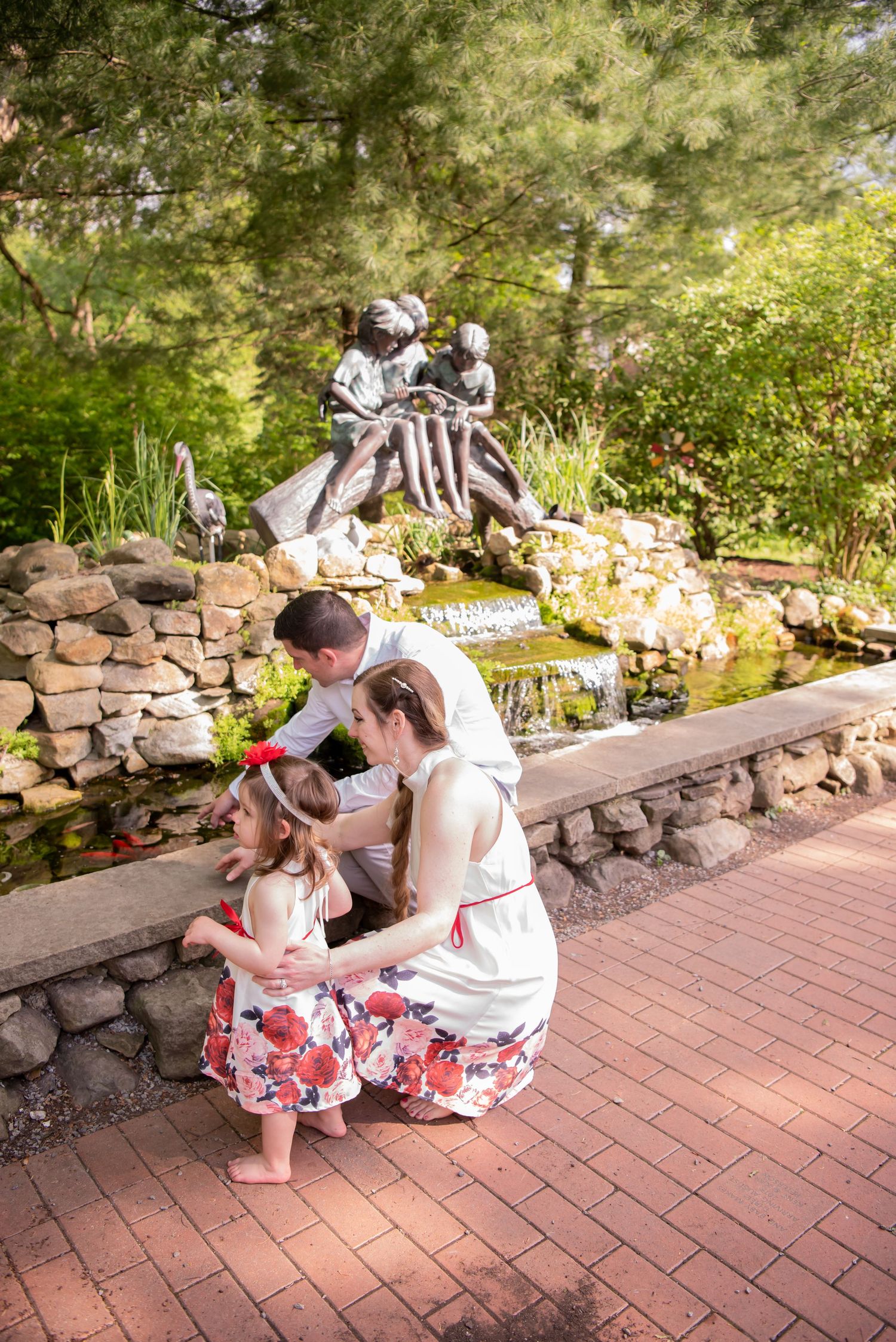 family of three looking at a fish pond in north hills
