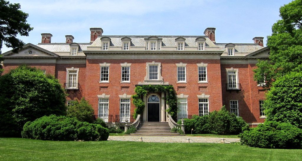 Elegant red brick Georgian mansion with symmetrical windows and dormer roof.