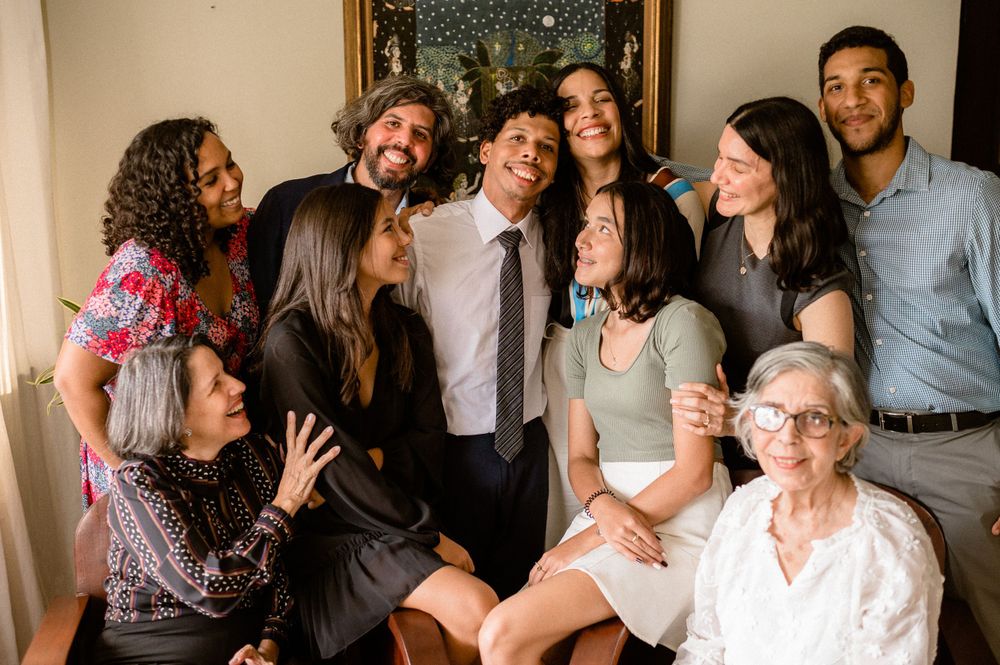 Large group celebrating together in a living room during special occasion.