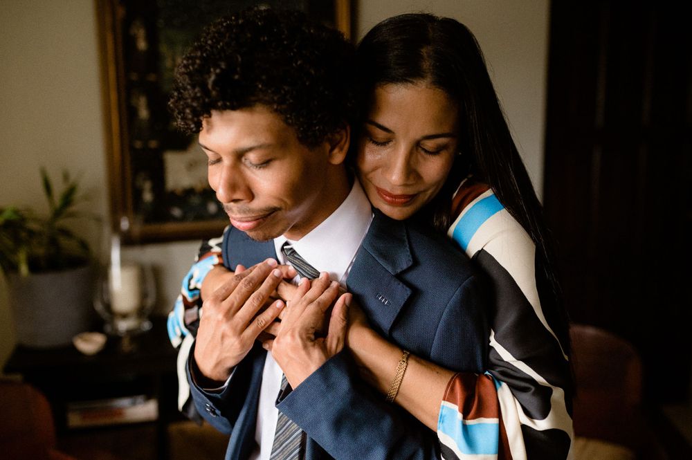 Intimate embrace between couple sharing a tender moment in formal attire.