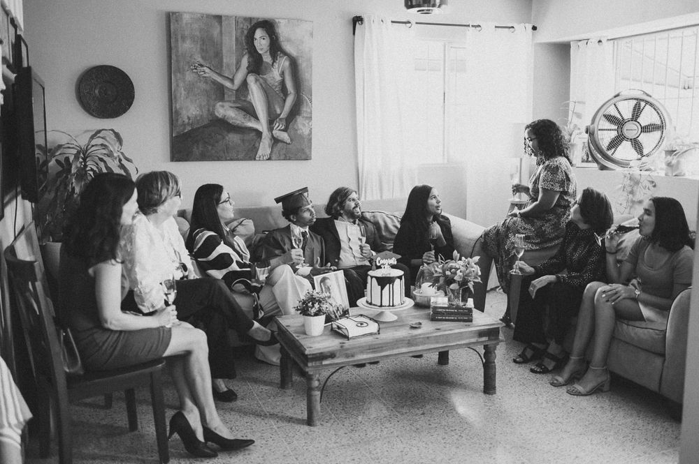 Vintage black and white photo of women gathered for social event in living room.