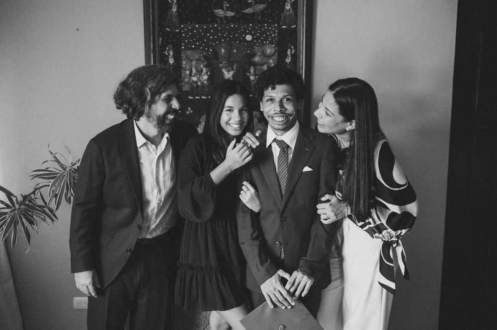 Candid black and white group shot showing laughter and joy indoors.